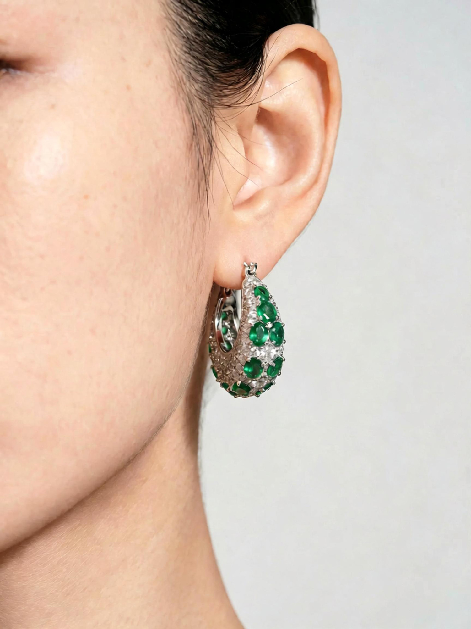 Angled overhead shot luxury green galaxy hoop earrings studio shot