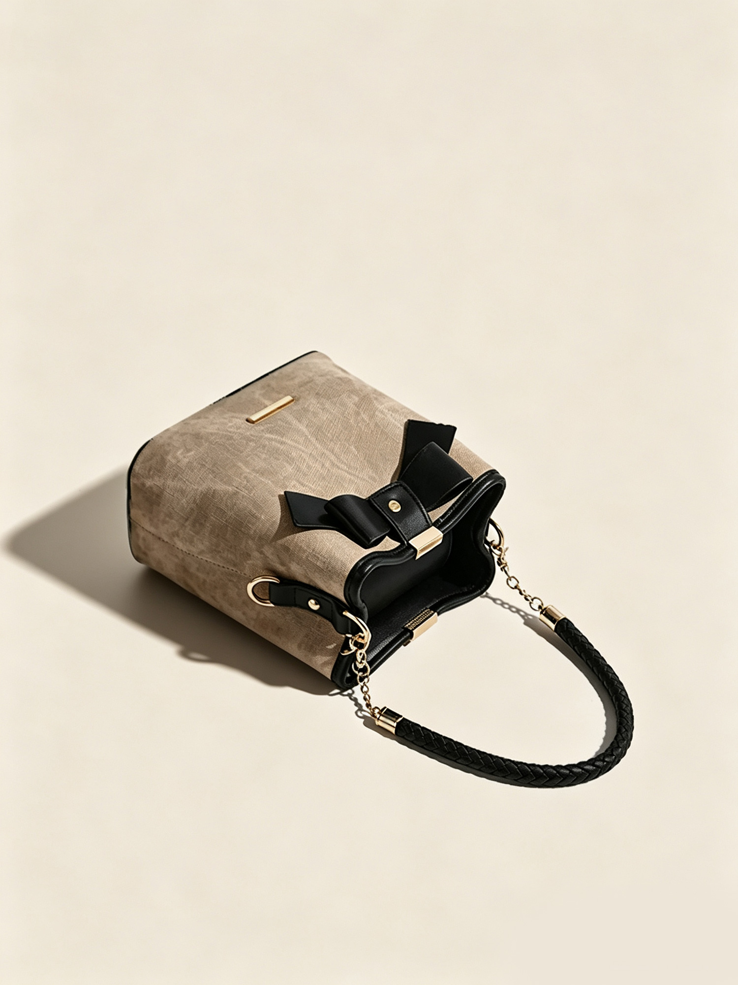 Close up view of black bow decoration and braided handle on bucket handbag