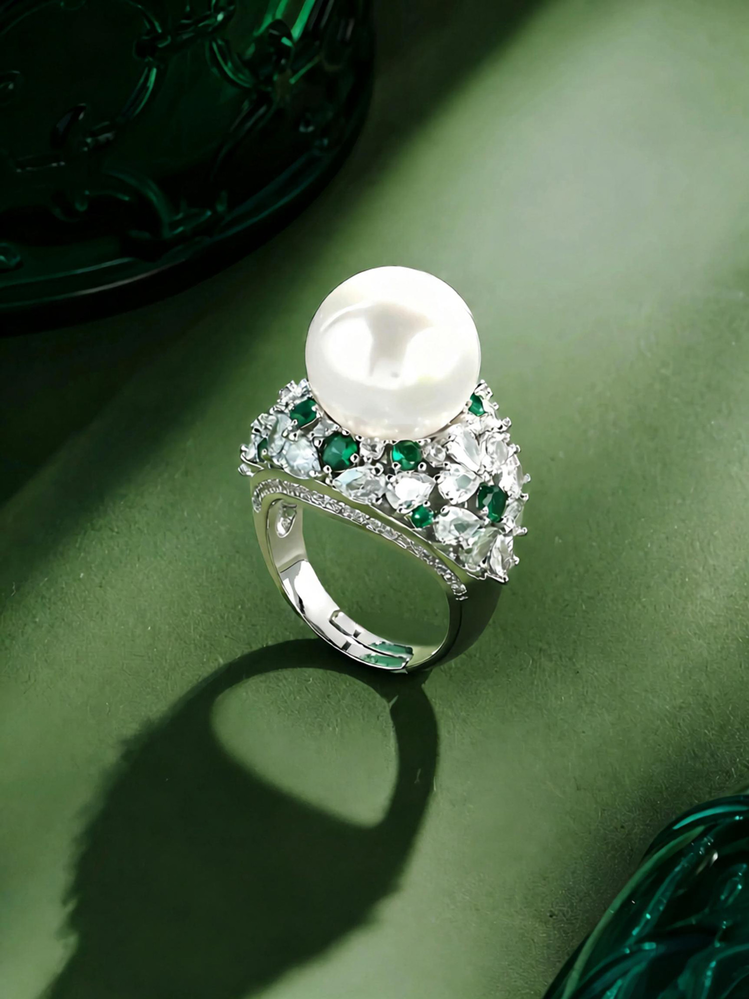 Floating pearl ring close‑up, elevated freshwater pearl surrounded by clear and green zircon border