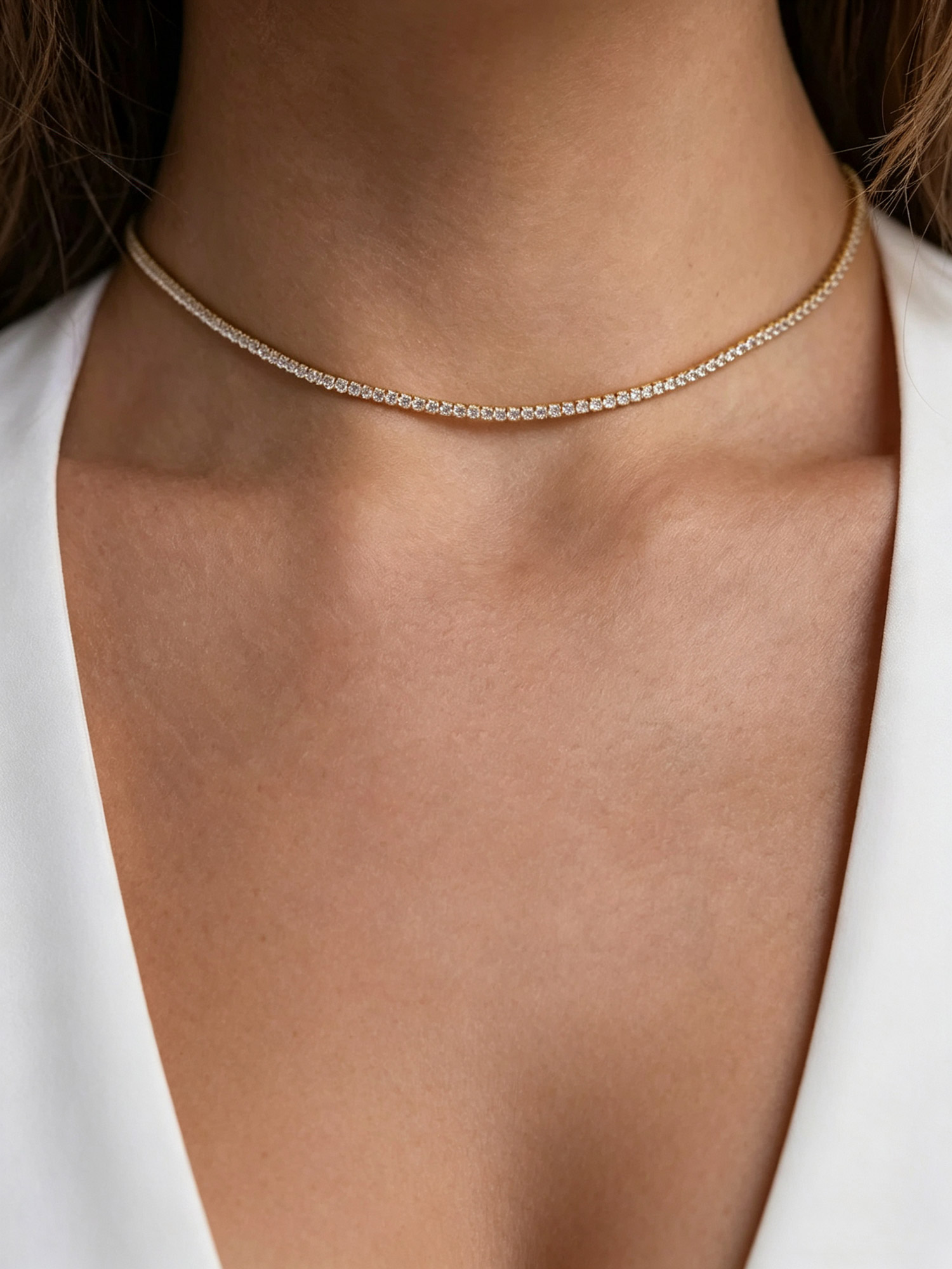 Lumina Tennis Necklace flat lay shot, continuous clear zircon stone chain on neutral stone surface