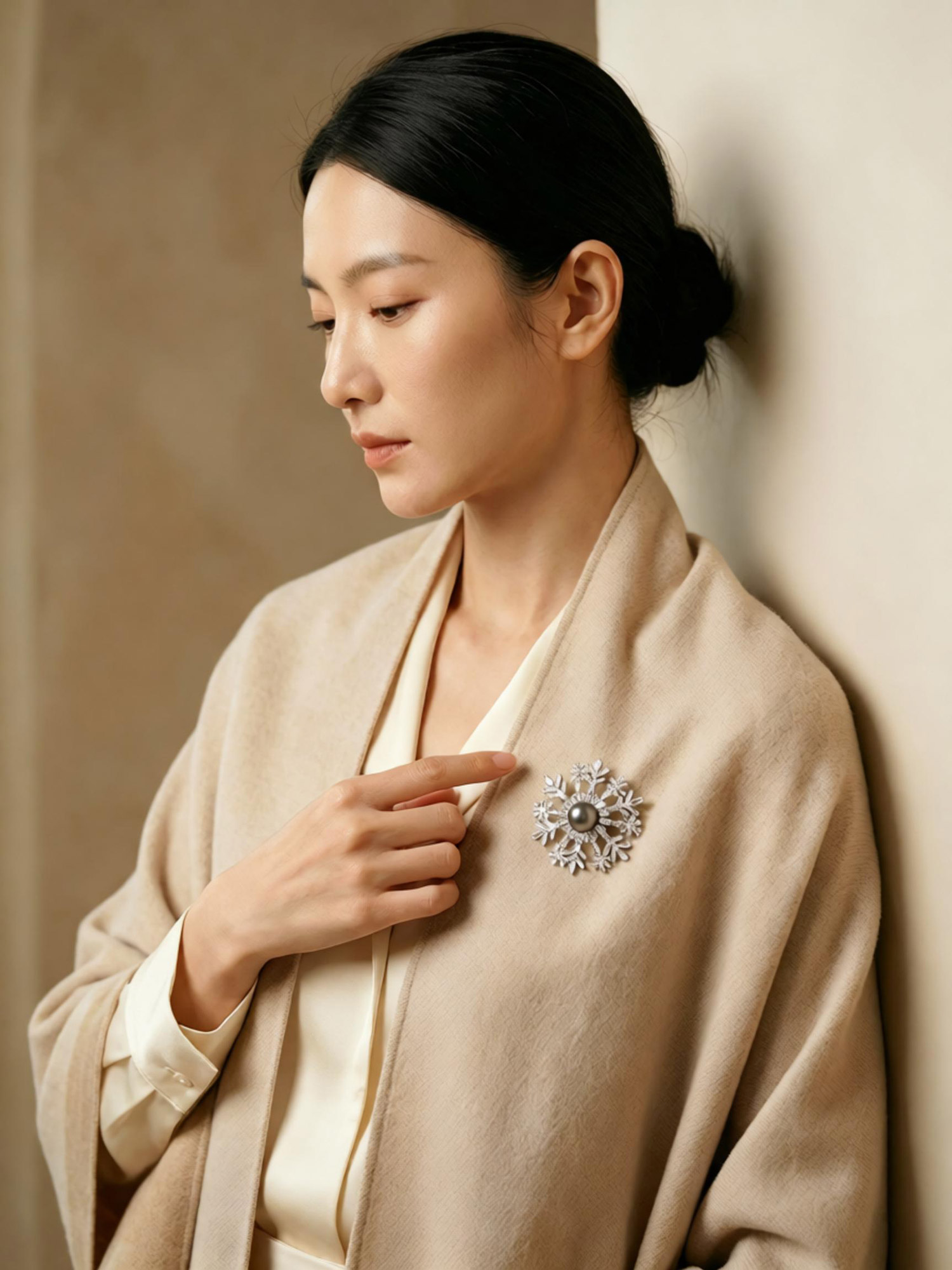 Overhead studio shot luxury snow tahiti pearl brooch resting on stone surface