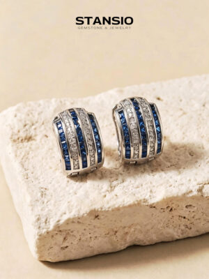 Stansio blue movement hoop statement earrings on textured stone background