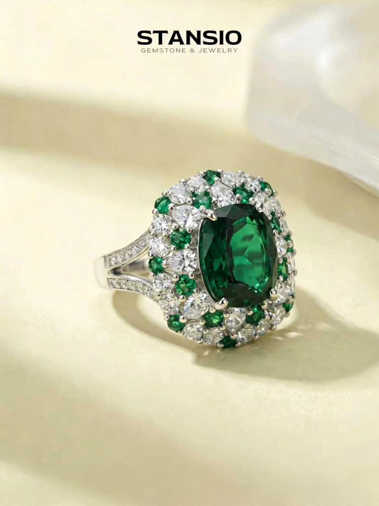 Stansio emerald journey ring worn on hand, central emerald halo cocktail ring for formal occasion