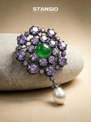 Stansio violet pearl brooch paired with vintage formal outfit, ornate two‑tone gem brooch on neutral fabric